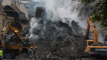 Bombeiros trabalham com escavadeiras e outros maquinários nos destroços do desabamento. Foto: Amanda Perobelli/ Estadão