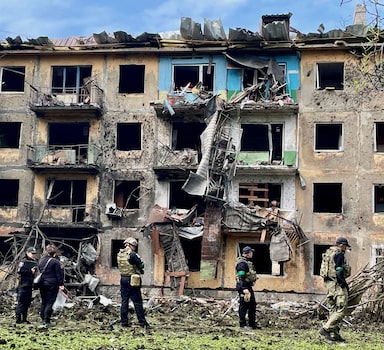 Ukrainian military personnel inspect the site of a missile strike in front of a damaged residential building, amid Russia's invasion, in Dobropillia, in the Donetsk region, Ukraine, April 30, 2022. REUTERS/Jorge Silva