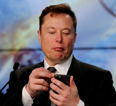 FILE PHOTO: Elon Musk looks at his mobile phone in Cape Canaveral, Florida, U.S. January 19, 2020. REUTERS/Joe Skipper/File Photo/File Photo