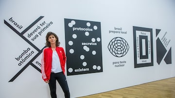Romy Pocztaruk ao lado de sua obra na exposição 'A Máquina do Mundo'. Foto: TIAGO QUEIROZ / ESTAD?O