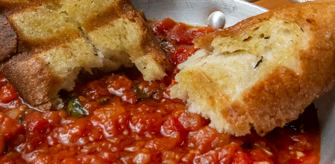 Panela com molho de tomate e duas fatias de pão dentro. Foto: TABA BENEDICTO