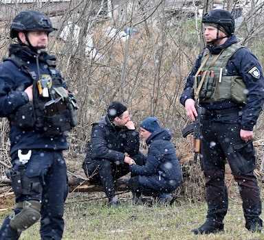 Ucranianos lamentam após autoridades encontrarem vala comum em Bucha