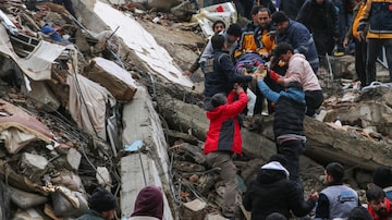 People and emergency teams rescue a person on a stretcher from a collapsed building in Adana, Turkey, Monday, Feb. 6, 2023. A powerful quake has knocked down multiple buildings in southeast Turkey and Syria and many casualties are feared. (IHA agency via AP). Foto: Agência IHA/via AP