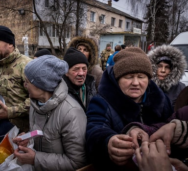 Residents crowd a pick-up truck distributing aid in Borodyanka, Ukraine, on Tuesday, April, 5, 2022. As many as 200 people are missing and presumed dead under the rubble of this small town that has been devastated by Russian airstrikes, the acting mayor said Tuesday. (Ivor Prickett/The New York Times)

