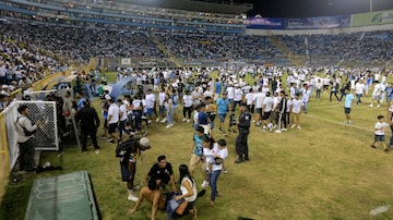 Supporters are helped by others following a stampede during a football match between Alianza and FAS at Cuscatlan stadium in San Salvador, on May 20, 2023. Nine people were killed May 20, 2023 in a stampede at an El Salvador stadium where soccer fans had gathered to watch a local tournament, police said. (Photo by Milton FLORES / AFP). Foto: Milton Flores/AFP