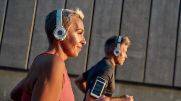 Morning jog. Happy and healthy middle-aged couple in headphones running together through the city street in the morning. Foto: Svitlana/Adobe Stock 