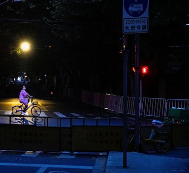 A woman wearing a face mask rides a shared bicycle on a closed street during lockdown, amid the coronavirus disease (COVID-19) pandemic, in Shanghai, China, May 19, 2022. REUTERS/Aly Song