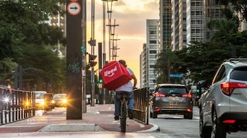 Entregador do aplicativo iFood atravessa a Avenida Paulista, em São Paulo. Foto: Daniel Teixeira / Estadão
