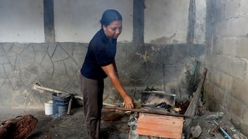A dona de casa Endy Perez cozinha no quintal de sua casa em um fogão à lenha improvisado, em Maracay, Venezuela. Foto: Manaure Quintero/Reuters