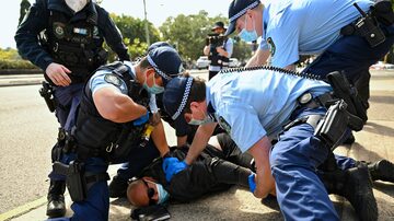 Policiais prendem manifestante durante protestos contra lockdown em Sydney, na Austrália. Foto: Steven Saphore/AAP/via AP