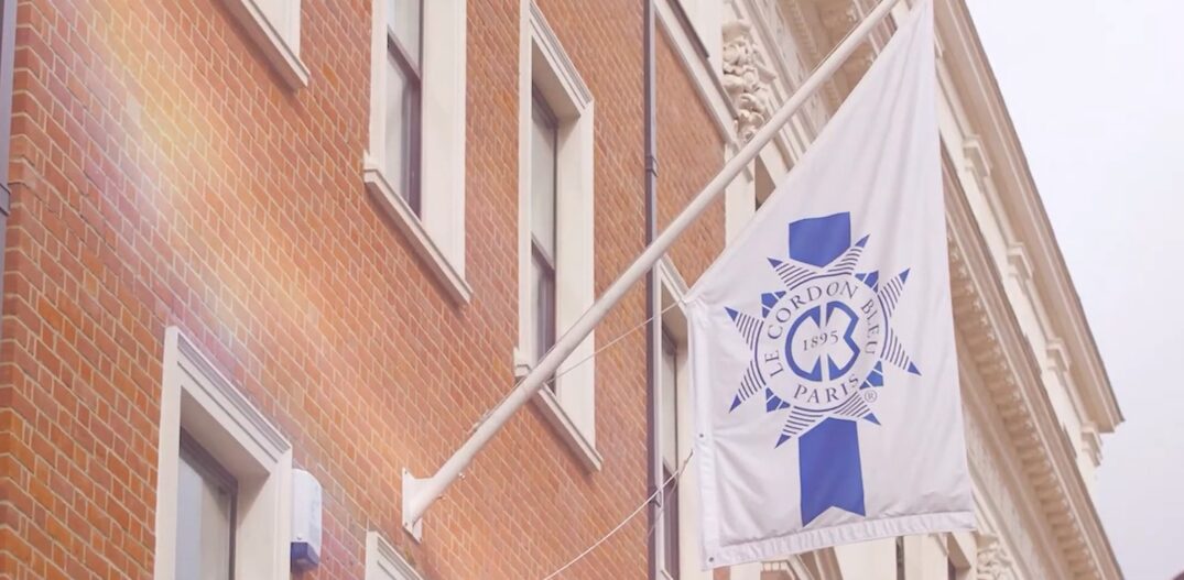 Fachada de tijolos aparentes com destaque para uma bandeira da escola de culinária Le Cordon Bleu. Foto: Reprodução / Sabor & Arte