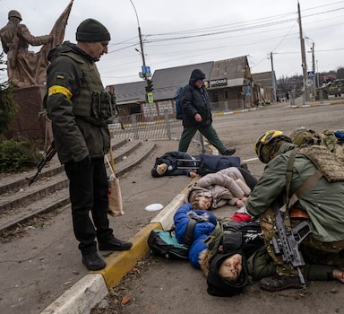 Moments after four civilians trying to evacuate were hit by Russian mortar fire, Ukrainian soldiers try to save Anatoly Berezhnyi Ñ the only one who still had a pulse Ñ in Irpin, west of Kyiv, on Sunday, March 6, 2022. Serhiy Perebyinis said he felt it was important that the death of his wife and children had been recorded in photographs and video. ÒThe whole world should know what is happening here,Ó he said. (Lynsey Addario/The New York Times) Ñ NO SALES Ñ 



