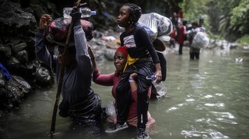 FILE - Haitian migrants wade through water as they cross the Darien Gap from Colombia to Panama in hopes of reaching the U.S., May 9, 2023. (AP Photo/Ivan Valencia, File)
