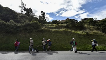 Venezuelanos das famílias Mendoza Landinez e Lomelly caminham pela Carretera Panamericana entre as cidades colombianas de Pasto e Ipiales. Foto: Luis ROBAYO / AFP