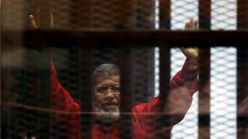 Ex-presidente do Egito, Mohamed Morsi, acena para visitantes por trás das grades. Foto: REUTERS/Amr Abdallah Dalsh