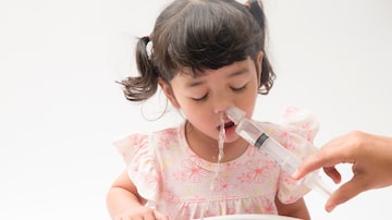 Asian mother making nasal wash for her baby girl by flushing kid'nose with syringe and saline. An Irrigation can benefit people who have sinus problems,nasal allergies isolated on white background. Foto: Asada/Adobe Stock  