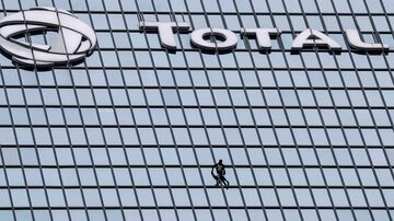 O alpinista Alain Robert, conhecido como o 'Homem-Aranha francês', escala torre no distrito La Defense, em Paris, em apoio a protesto contra a reforma da previdência. Foto: Thomas Samson/AFP