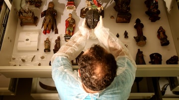 Museólogo observa peças da coleção Magia Negra,no Museu da República, no Rio de Janeiro. Foto: Wilton Junior/Estadão