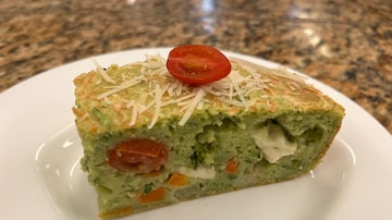 Em um prato de louça branca, uma fatia de torta de legumes com queijo branco, com recheio de massa esverdeada e que contém cubos de queijo braco, pedaços de tomate, de cenoura, brócolis e abobrinha. Foto: Luigi Di Fiore