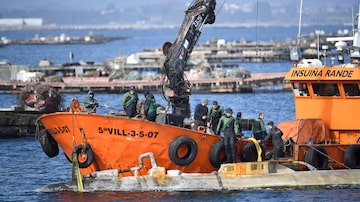 Spanish Guardia Civil stand as boat crew members tie an alleged narco-submarine before towing it, off Illa de Arousa, in Galicia region, northwestern Spain, on March 14, 2023. (Photo by Miguel RIOPA / AFP). Foto: Miguel Riopa/AFP
