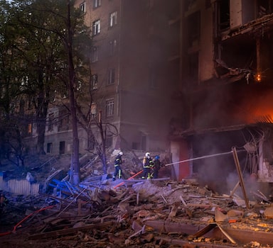 Firefighters try to put out a fire following an explosion in Kyiv, Ukraine on Thursday, April 28, 2022. Russia mounted attacks across a wide area of Ukraine on Thursday, bombarding Kyiv during a visit by the head of the United Nations. (AP Photo/Emilio Morenatti)