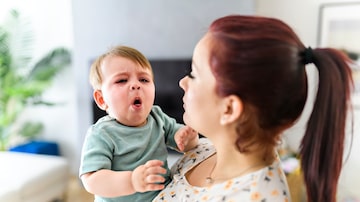A mother holding child baby on the living room. The baby is sick having some cough. Foto: Louis-Photo/Adobe Stock      