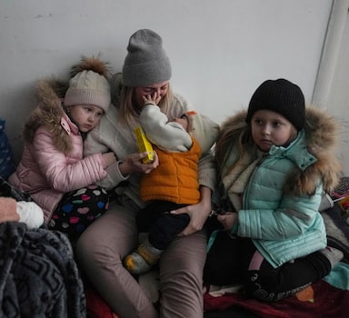 FILE - Women and children sit on the floor of a corridor in a hospital in Mariupol, eastern Ukraine, Friday, March 11, 2022. (AP Photo/Evgeniy Maloletka, File)