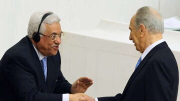 O presidente palestino, Mahmoud Abbas (e) congratula o presidente de Israel, Shimon Peres, após este discursar no parlamento turco em Ancara. 13/11/07. Foto: Burhan Ozbilici/AP