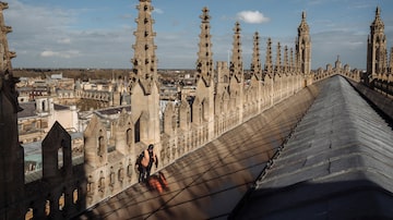 Toby Lucas, cuja empresa instalou painéis solares, no telhado da King's College Chapel em Cambridge, Inglaterra, em 14 de março de 2024. A King's College Chapel é um dos vários marcos britânicos que instalaram painéis solares, agradando os defensores do clima e irritando alguns tradicionalistas