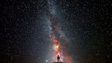 Man on top of a mountain observing the universe. Foto: quickshooting/Adobe Stock