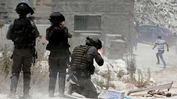 Membro da policia israelense dispara em manifestantes palestinos durante protesto contra assentamentos judeus na cidade de Beita, na Cisjordânia. Foto: Mohamad Torokman / Reuters
