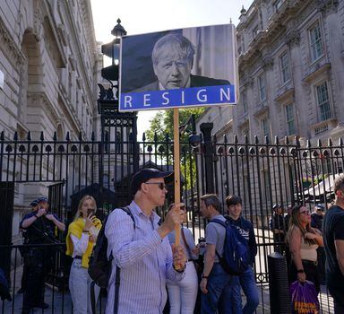 A demonstrator holds a placard depicting Britain's Prime Minister Boris Johnson while attending a workers protest outside the gates of Downing Street, in London, Friday, May 27, 2022. An investigative report released Wednesday blamed British Prime Minister Boris Johnson and other senior leaders for allowing boozy government parties that broke the U.K.'s COVID-19 lockdown rules, and while Johnson said he took "full responsibility" for the breaches, he insisted he would not resign. (AP Photo/Alberto Pezzali)