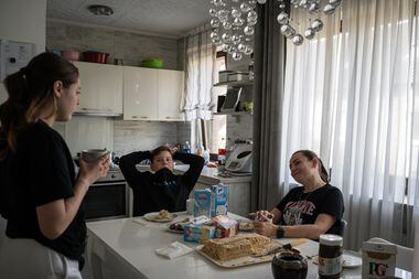 Alex (center) eats cake and tea at his home in Germany with his mother, Svetlana Ebert (right) and his sister Selena.