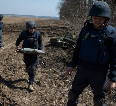 Ukrainians investigate a bombing site in Bezruky, Ukraine, near Kharkiv, April 7, 2022. In recent days, the scatterable mines, banned under international law, have begun turning up in Ukraine, imperiling civilians even in areas where Russian troops have withdrawn. (Tyler Hicks/The New York Times)