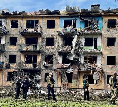 Ukrainian military personnel inspect the site of a missile strike in front of a damaged residential building, amid Russia's invasion, in Dobropillia, in the Donetsk region, Ukraine, April 30, 2022. REUTERS/Jorge Silva