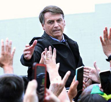 Brazilian President Jair Bolsonaro is cheered while departing after he rode a motorcycle along with other bikers in Orlando, Florida on June 11, 2022. - Bolsonaro visits central Florida after attending the 9th Summit of the Americas in Los Angeles, California. Besides meeting with Brazilian citizens he helped inaugurate a new Brazilian consulate in Florida. (Photo by Gregg Newton / AFP)