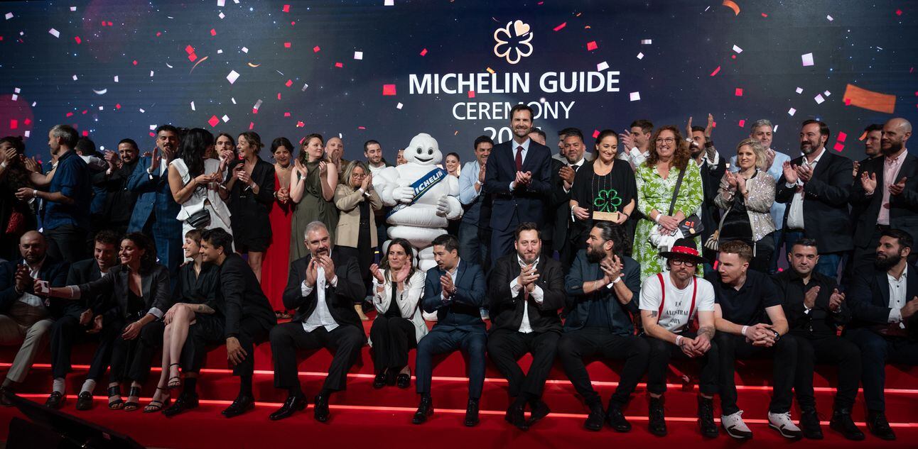 Pessoas festejam sobre o palco da premiação, ao fundo lê-se Michelin Guide. Foto: Guillermo Llamos