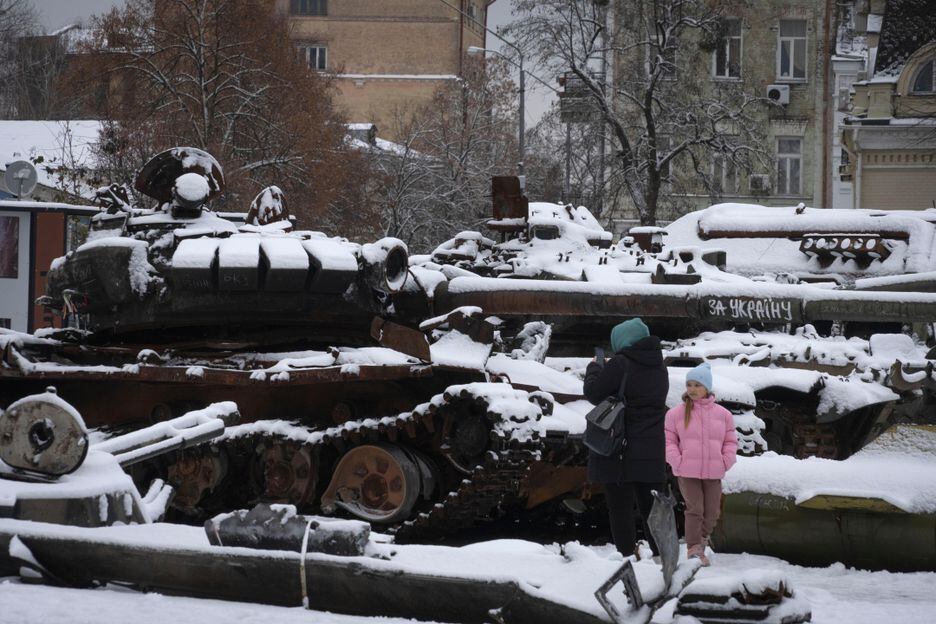 Mulher e criança olham os veículos militares russos danificados no centro de Kiev.
