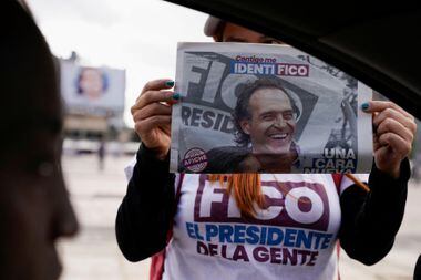 Mulher segura um panfleto com a imagem do candidato á presidência da Colômbia, Federico Gutierrez