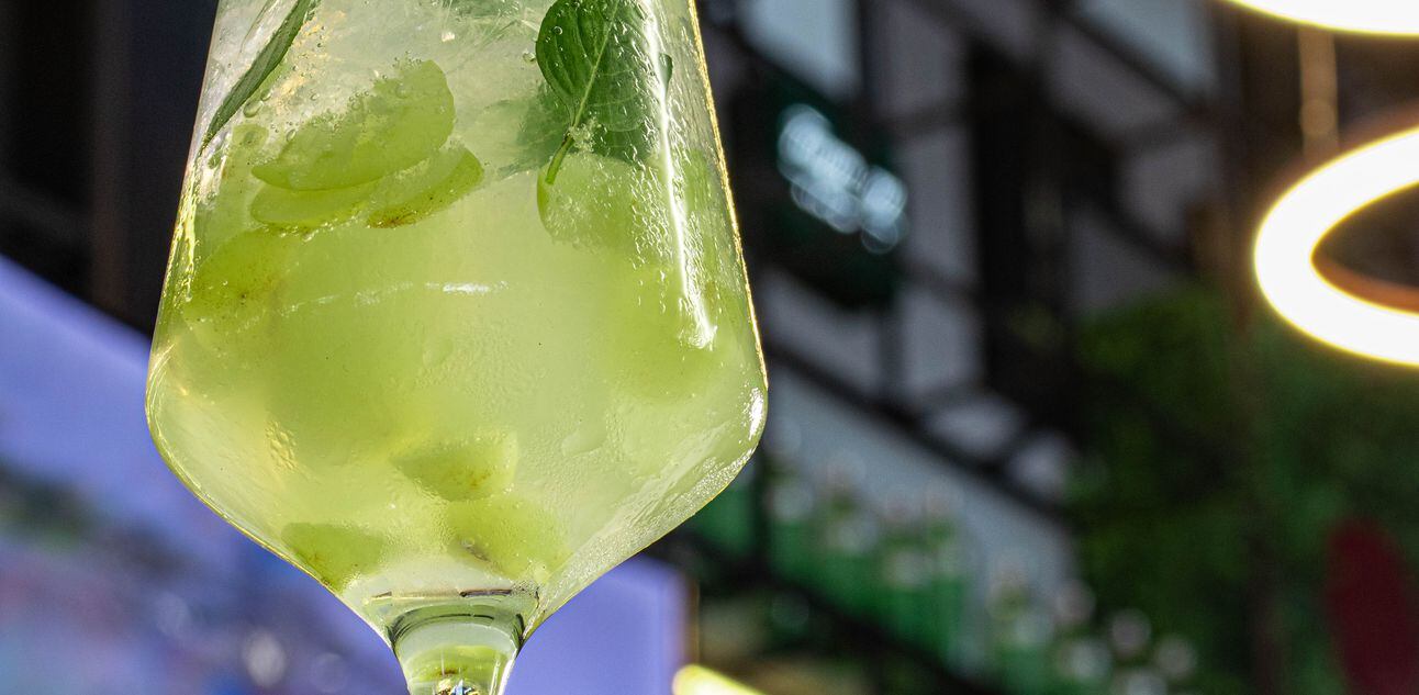 Taça com bebida verde, uvas e folhas de manjericão. Foto: Martin Bar I Agência Dots